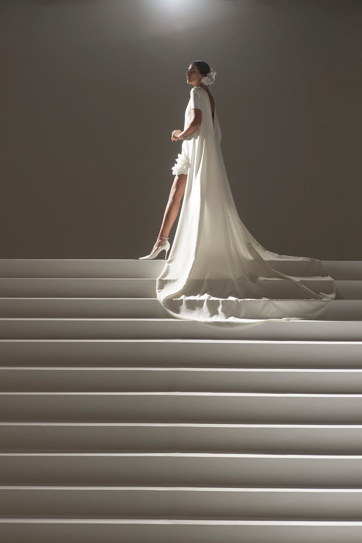 Crepe short wedding dress with draped train and short-sleeve add-on from haute couture designer Stephane Rolland available at Estrelle Bridal Toronto.