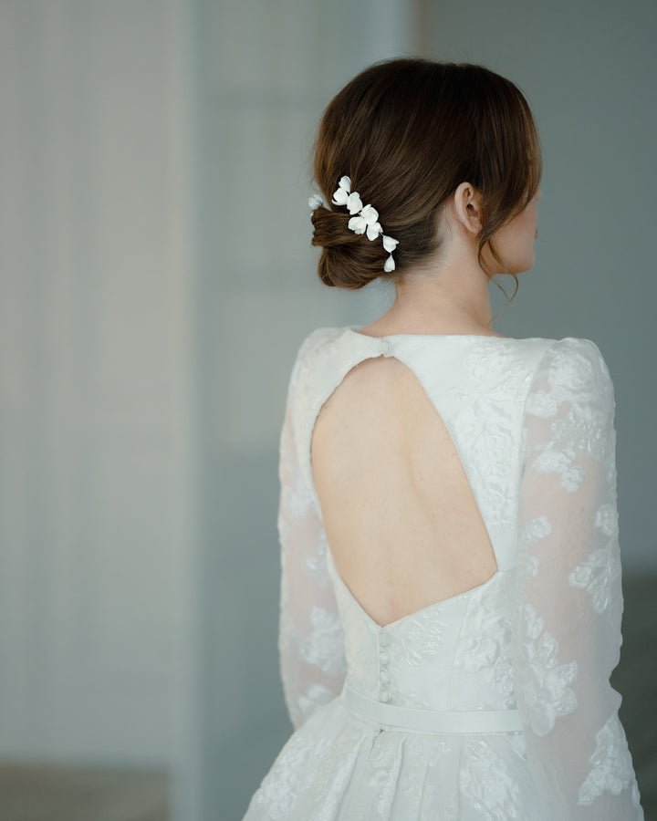 Elegant and romantic hair pins with low bun for bride on wedding.