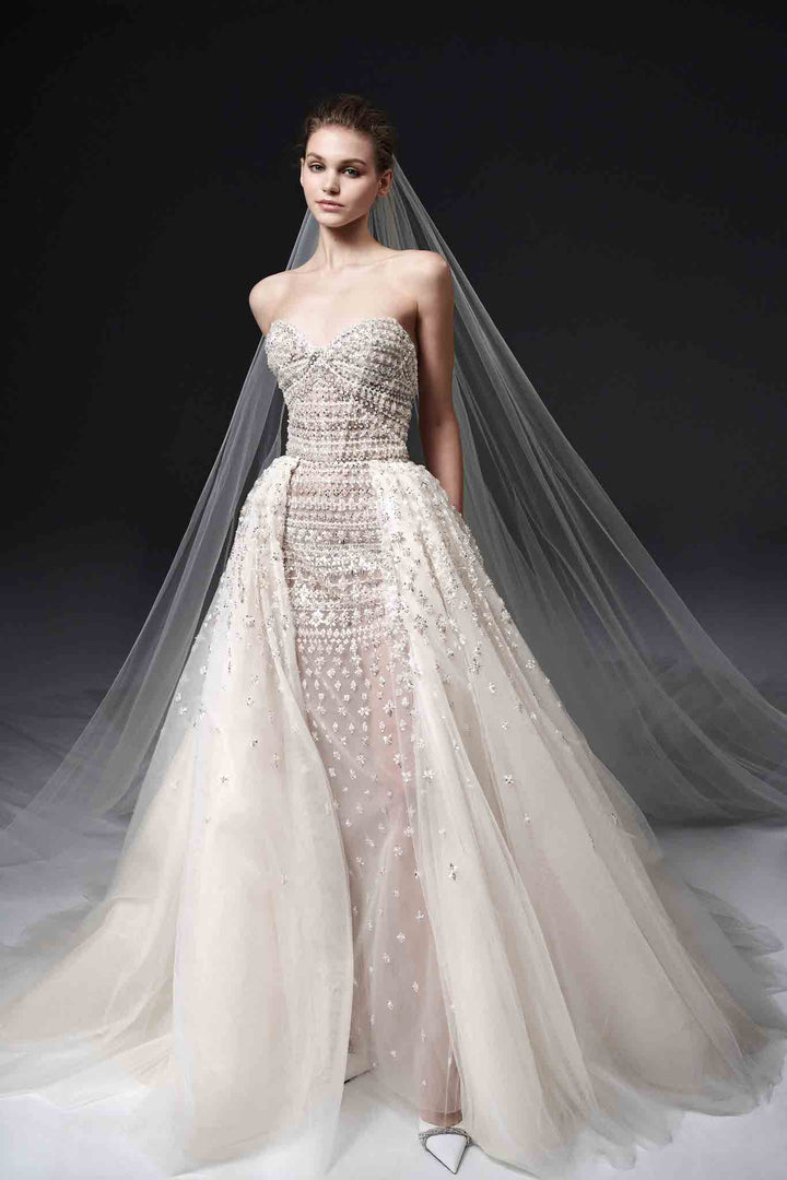 Full beaded sheath strapless wedding dress with detachable ballgown overskirt made by Nicole Felicia Couture available at Estrelle Bridal Toonto