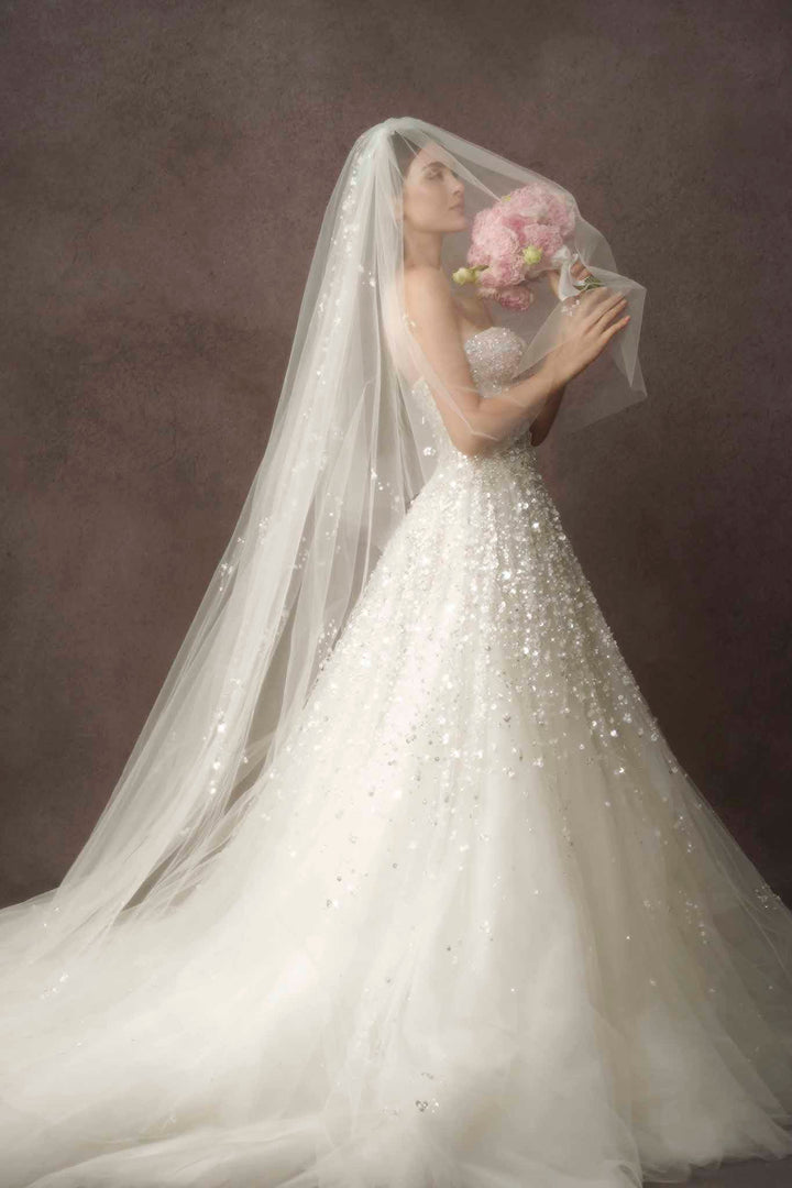 Romantic and elegant bride with exquisite beading ballgown, tulle veil and bouquet